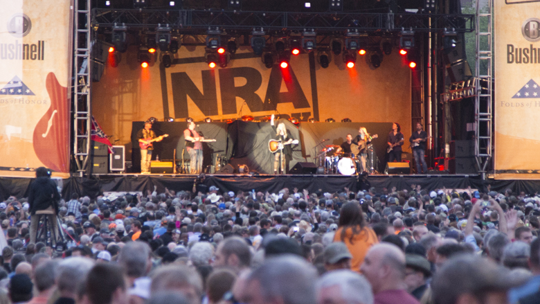 NRA Country Stage with a country band playing music in front of a huge crowd.