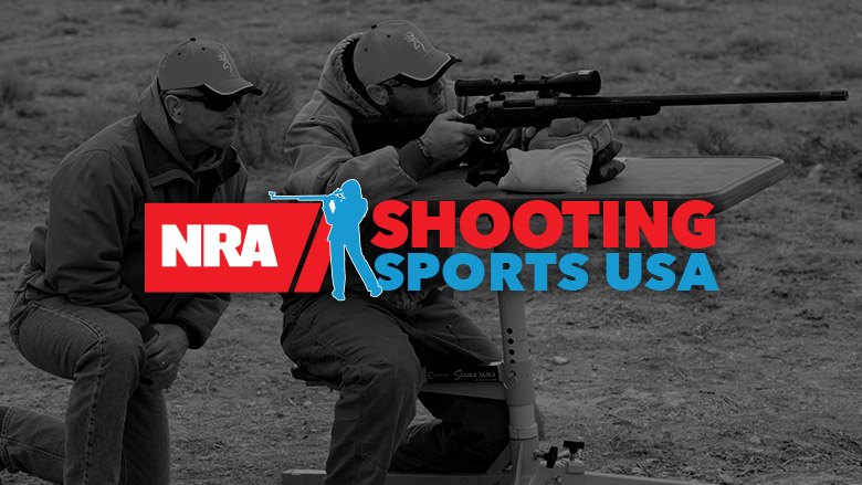 NRA Shooting Sports USA Logo on top of darkened image of a man shooting a rifle with a spotter by his side