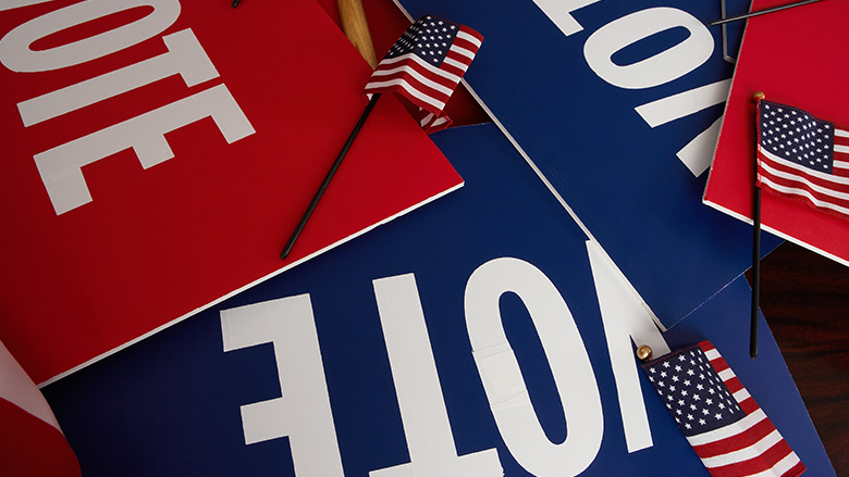 Pile of VOTE signs and American Flags